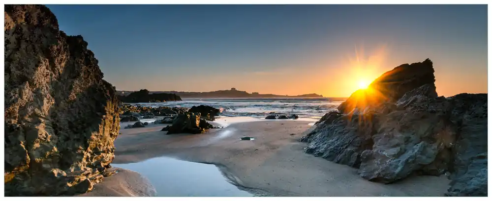 Glasbild Sonnenuntergang hinter einem Felsen am Strand 32 x 80 cm Geprüft